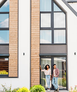 Man and woman standing outside a modern house