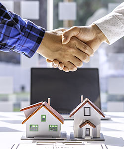 Real estate agents and clients shake hands